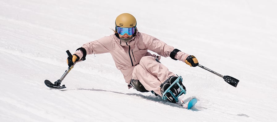 Adaptive skier wearing the Smith x High Fives goggles and helmet