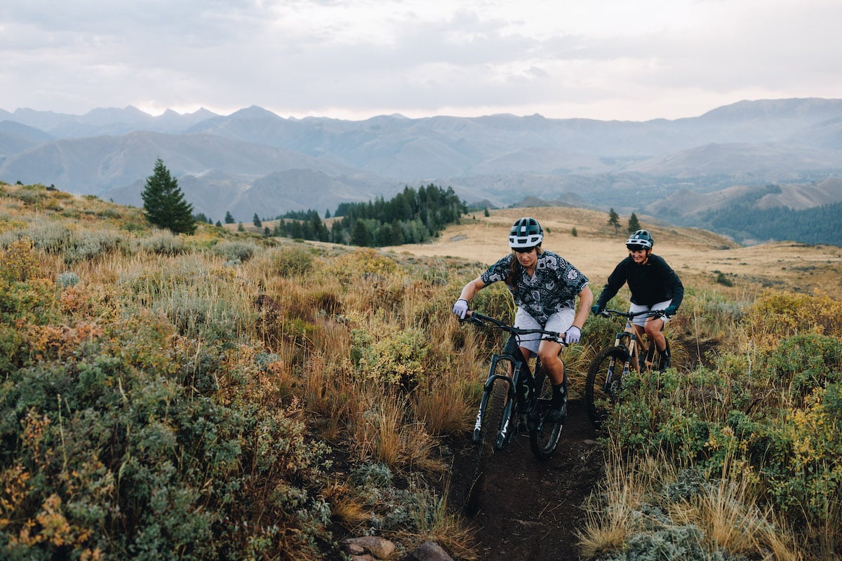 Women mountain biking in SMITH x Wild Rye collaboration apparel and gear.